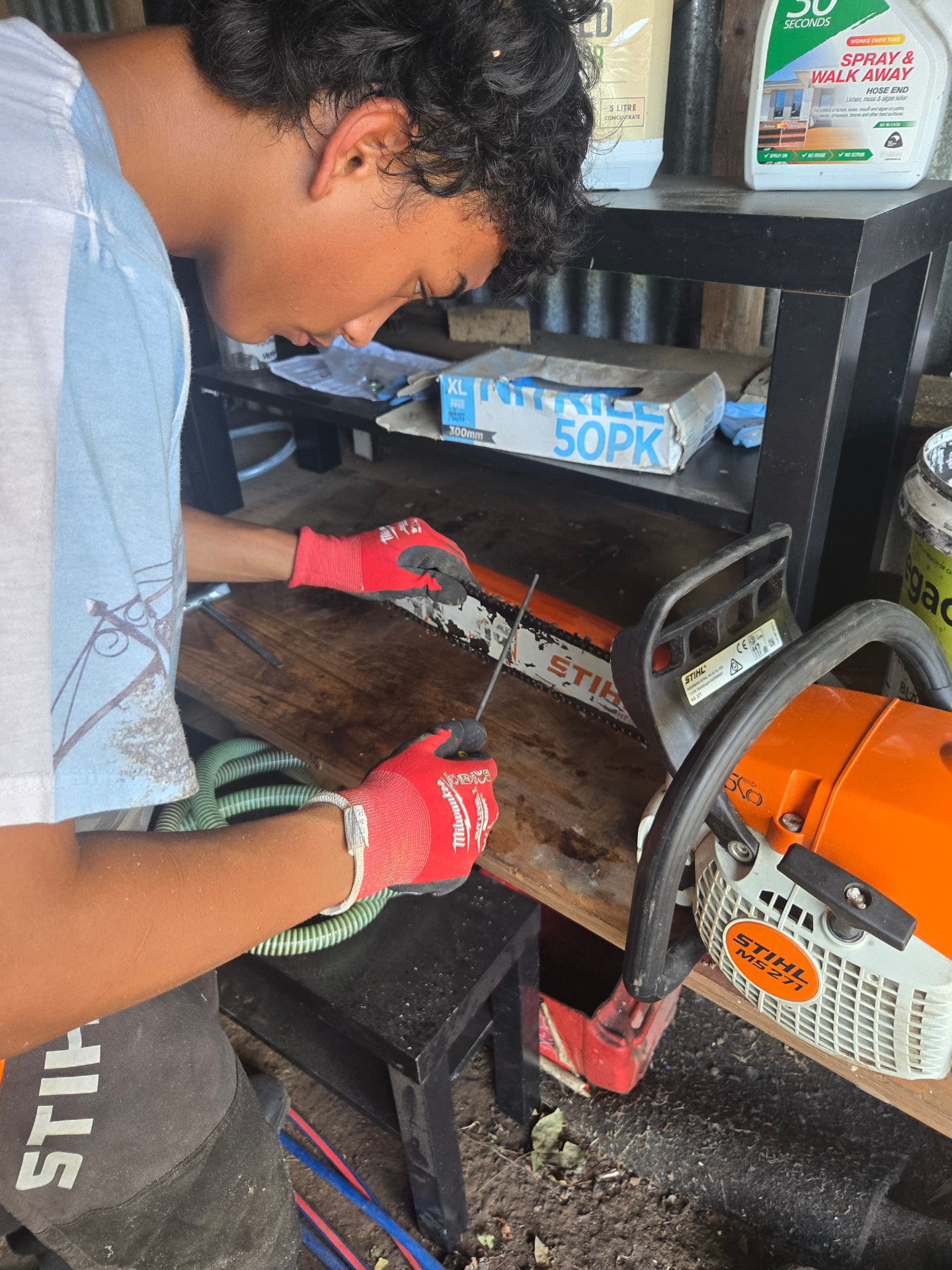 Shades sharpening a Stihl chainsaw in the workshop